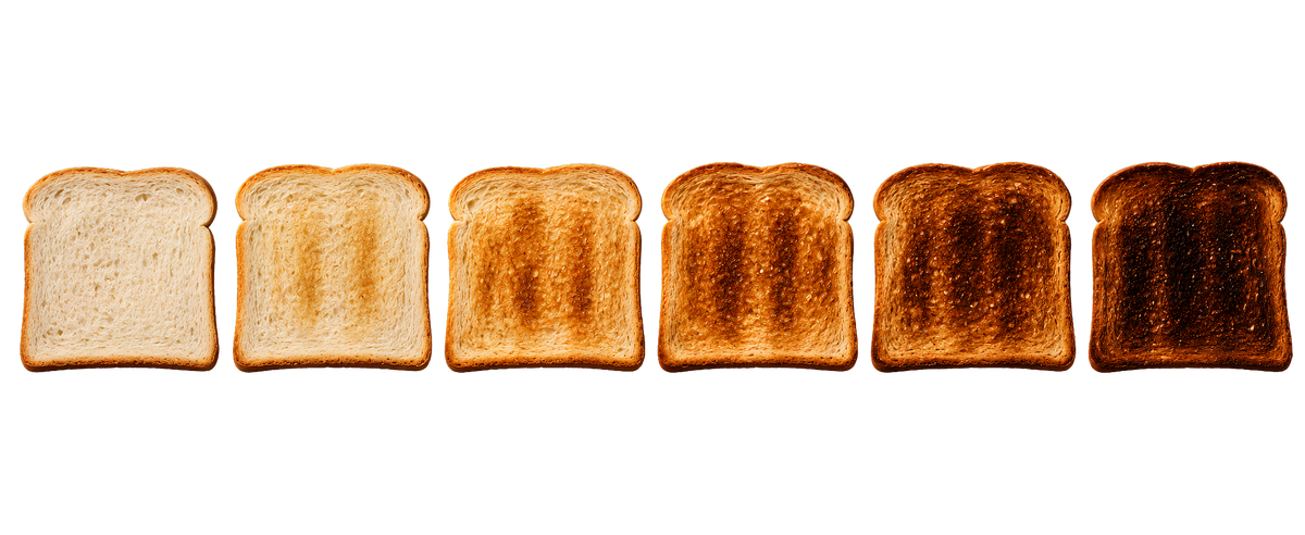 Six slices of bread arranged in a row on a white background, showing a progression from lightly toasted to fully burnt.