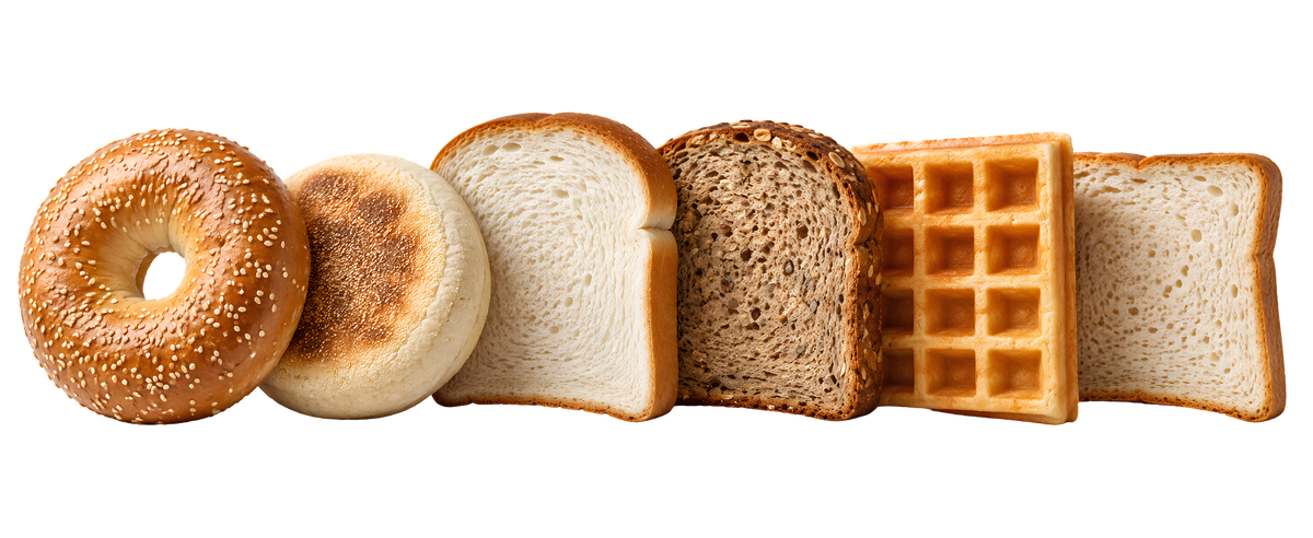 Six different types of baked bread and breakfast items arranged in a row on a solid white background, including a sesame bagel, a plain bagel, a white bread slice, a brown bread slice, a waffle, and another white bread slice.